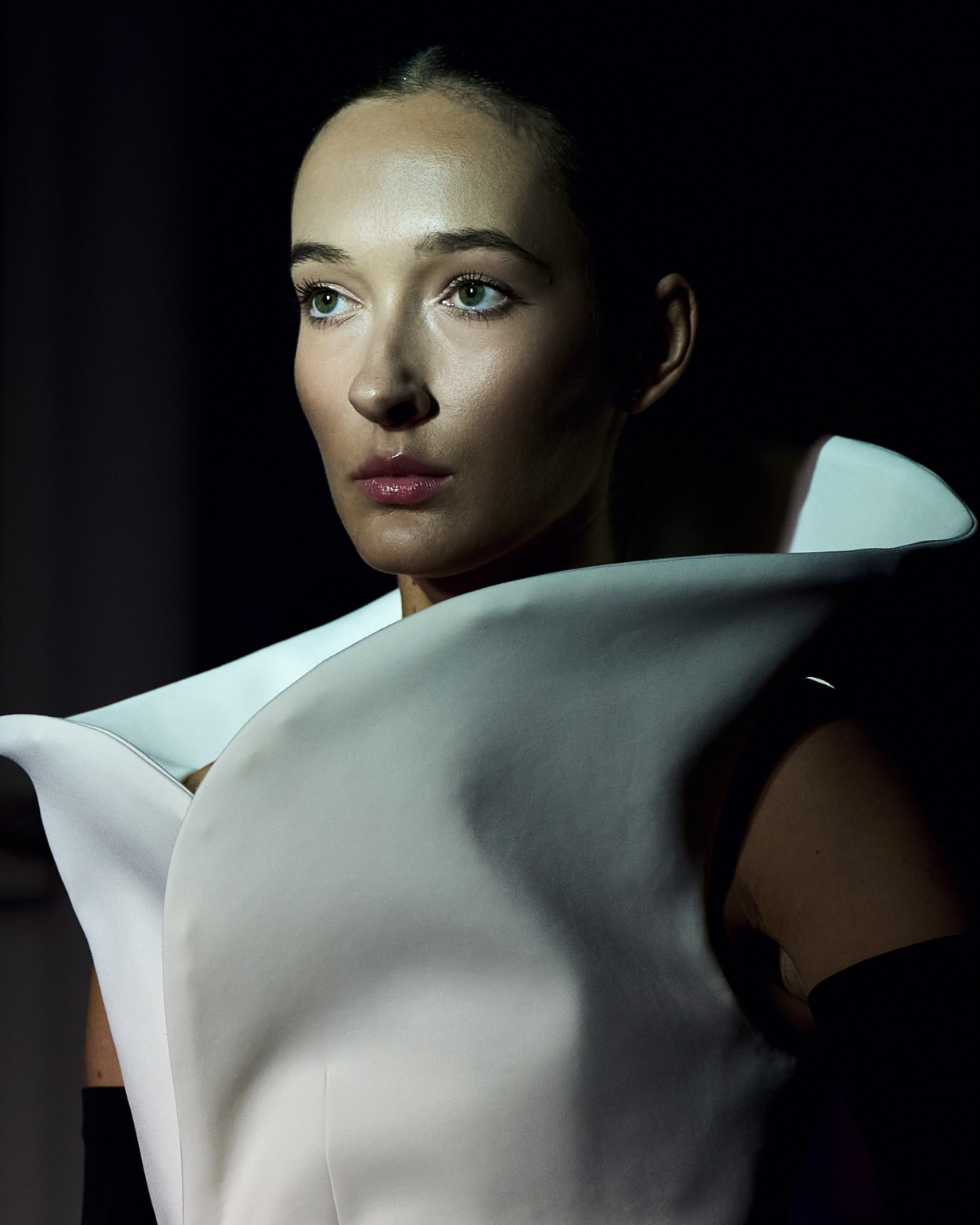 Fashion portrait, model wearing sculptural white structured top, dramatic chiaroscuro lighting