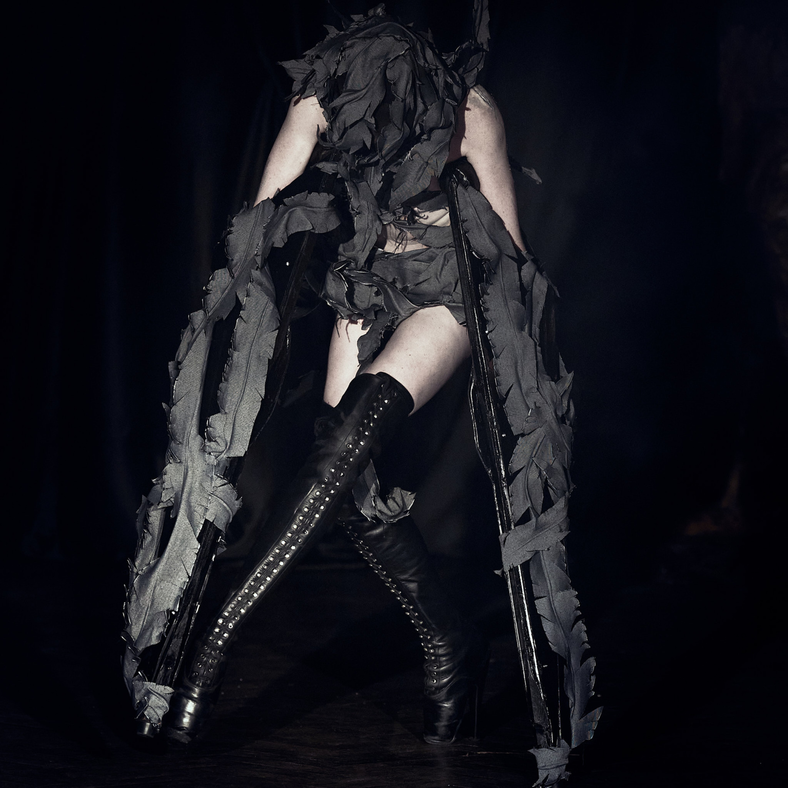 Fashion show, LFW AW26 Silvercity, model wearing long platform boots, dark moody lighting