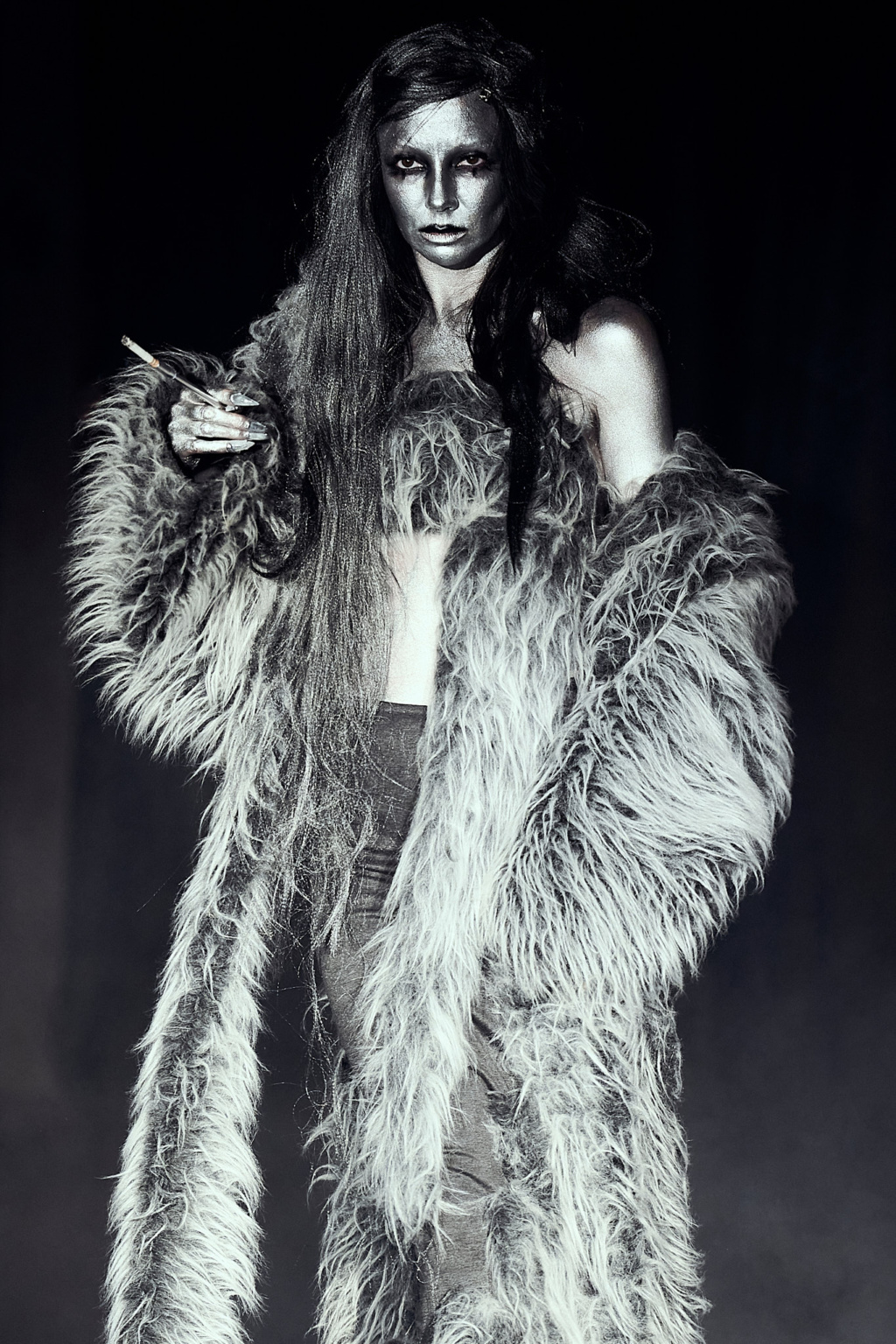 Fashion show, LFW AW26 Silvercity, model wearing long silver fur coat, dark moody lighting